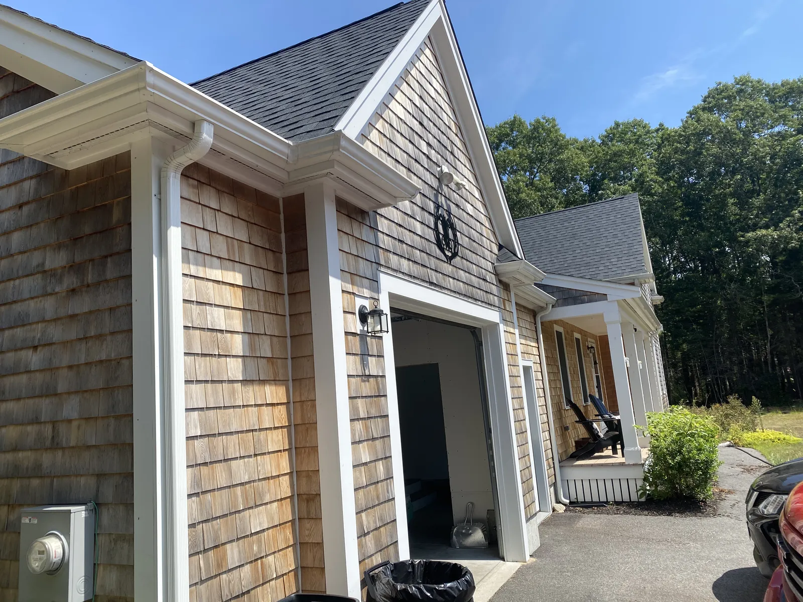 Cedar shingle garage with white gutter and downspout installation