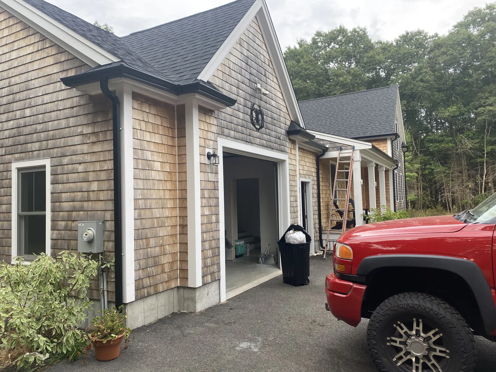 Cedar shingle garage with black gutter system installed along the eaves