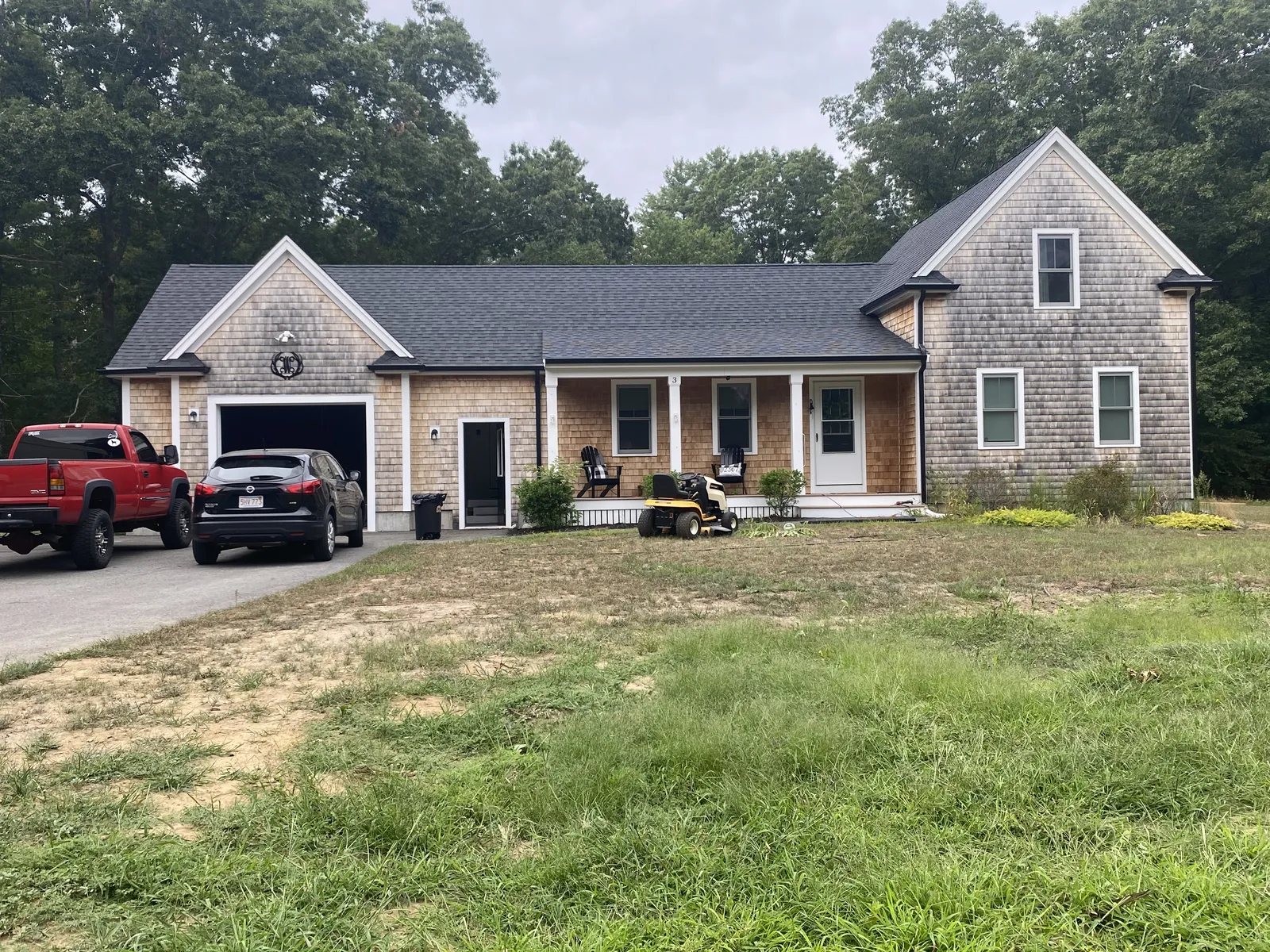 Front exterior of a cedar shingle home with finished black seamless gutters