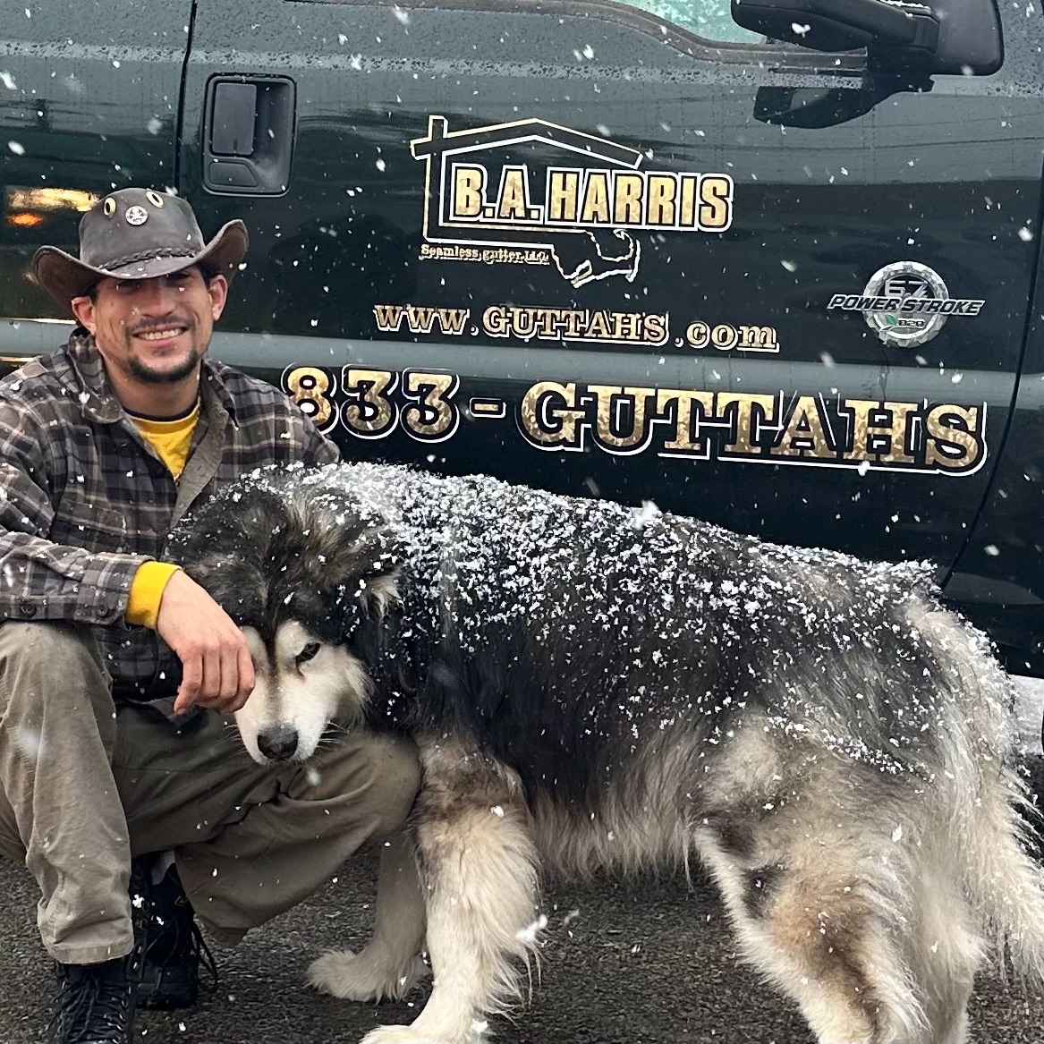 Brad Harris, owner of B.A. Harris Seamless Gutter, with his dog in front of the company truck