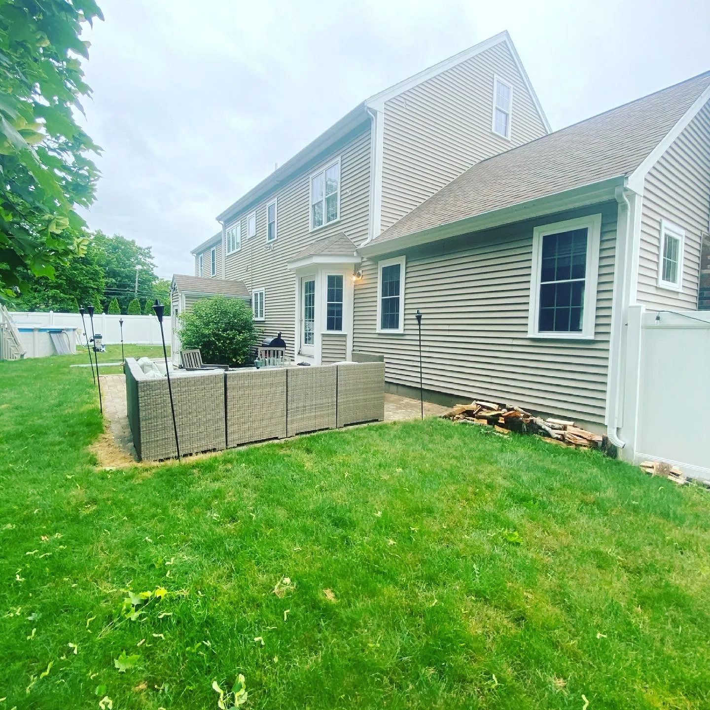 Backyard view of a home after exterior cleaning with bright siding and clean gutters